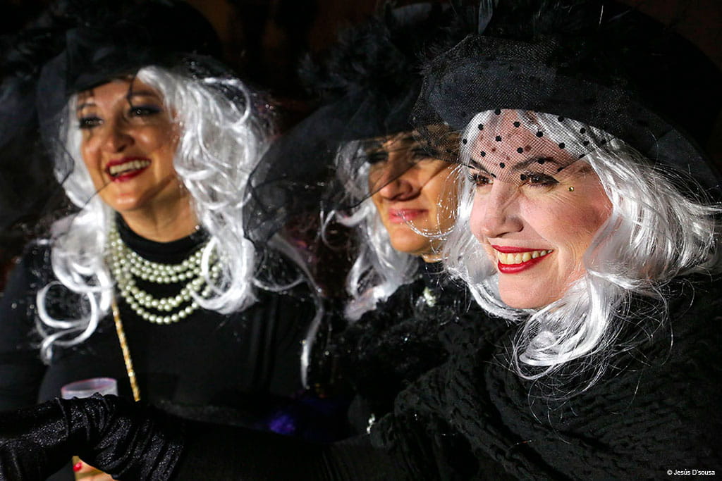 People dressed up in white wigs and black hats at the carnival in Tenerife.