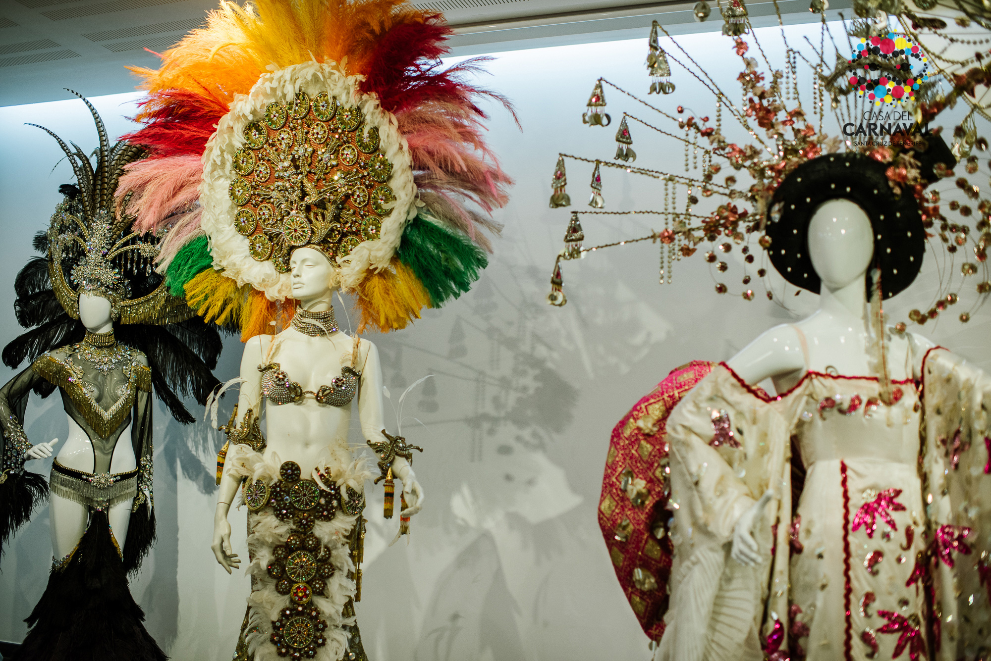 Mannequins in costumes from the Carnival of Santa Cruz de Tenerife, showing colorful headdresses.