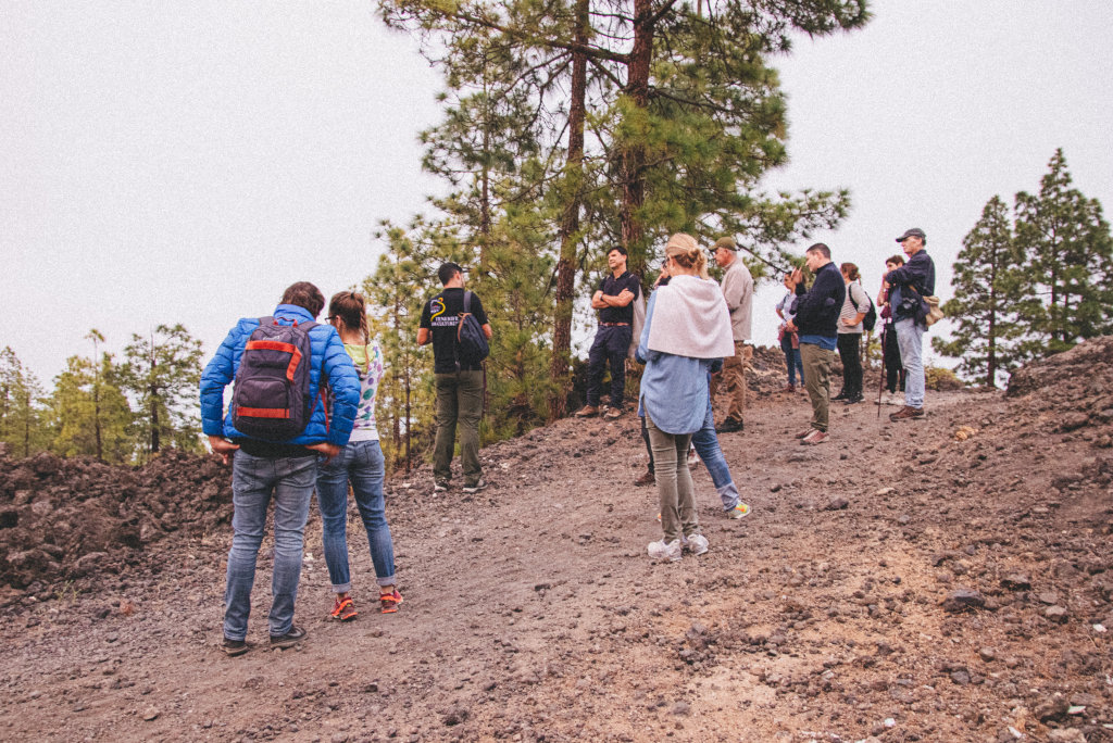 Group of people walking along volcanic trail in Tenerife.