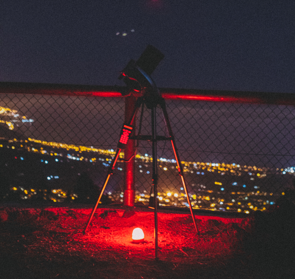 Telescope in viewpoint with urban night lights in Tenerife.