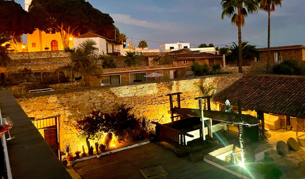 Illuminated courtyard with stone walls and greenery in a house in Tenerife.