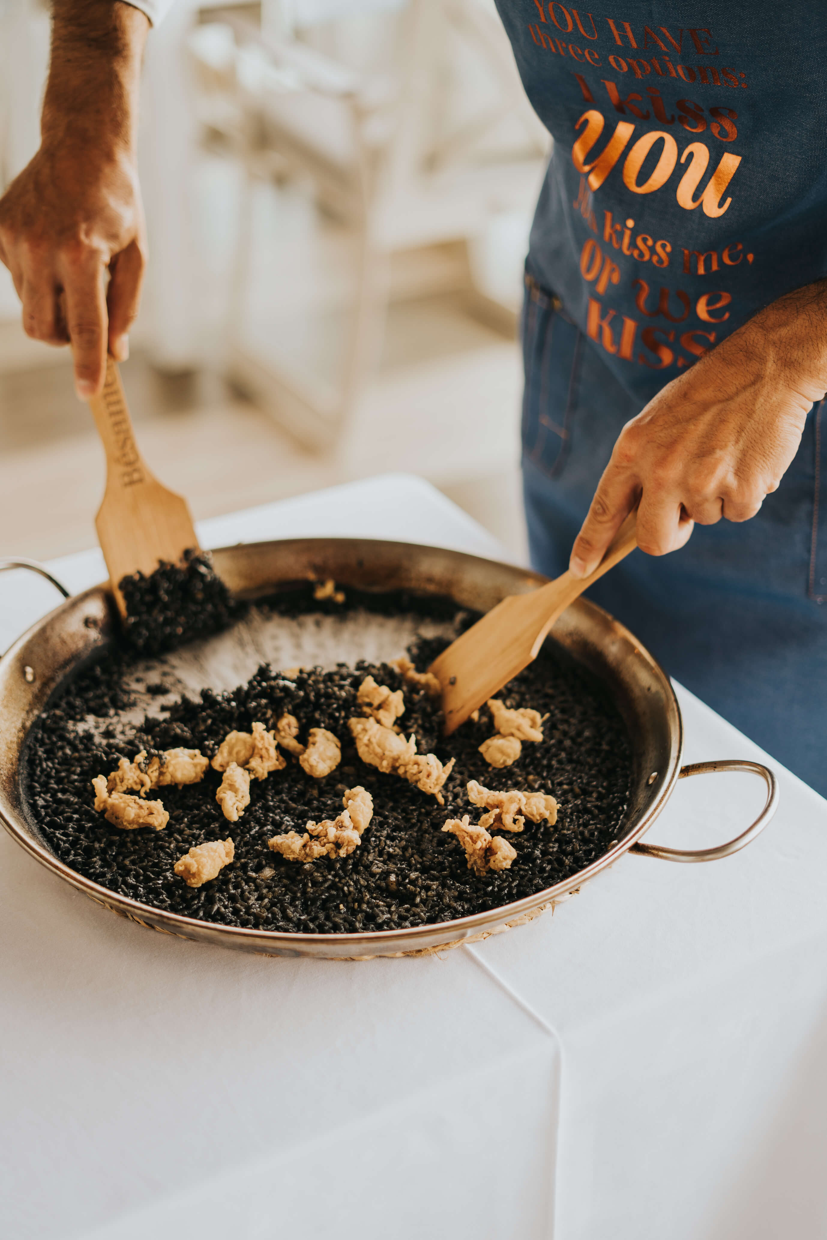 Preparation of black rice with seafood in a paella pan in Tenerife.
