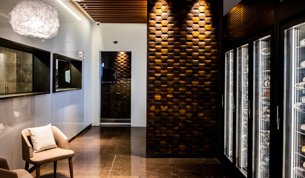 Cellar entrance with chairs, mirrors and door with text La Reserva de Juan Carlos.