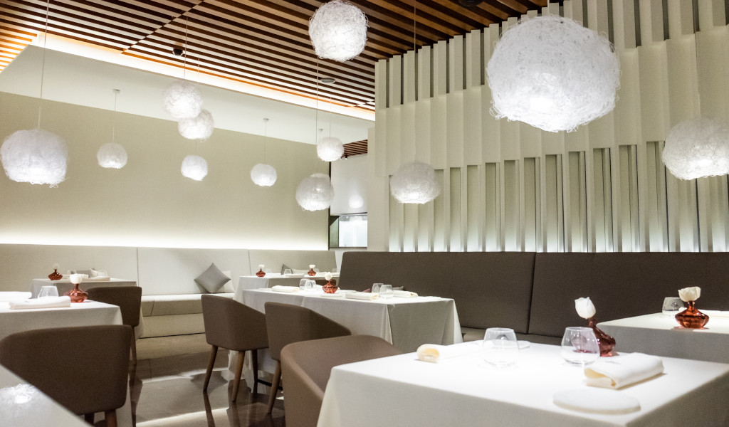 Restaurant in Tenerife with white tables and decorative pendant lamps.
