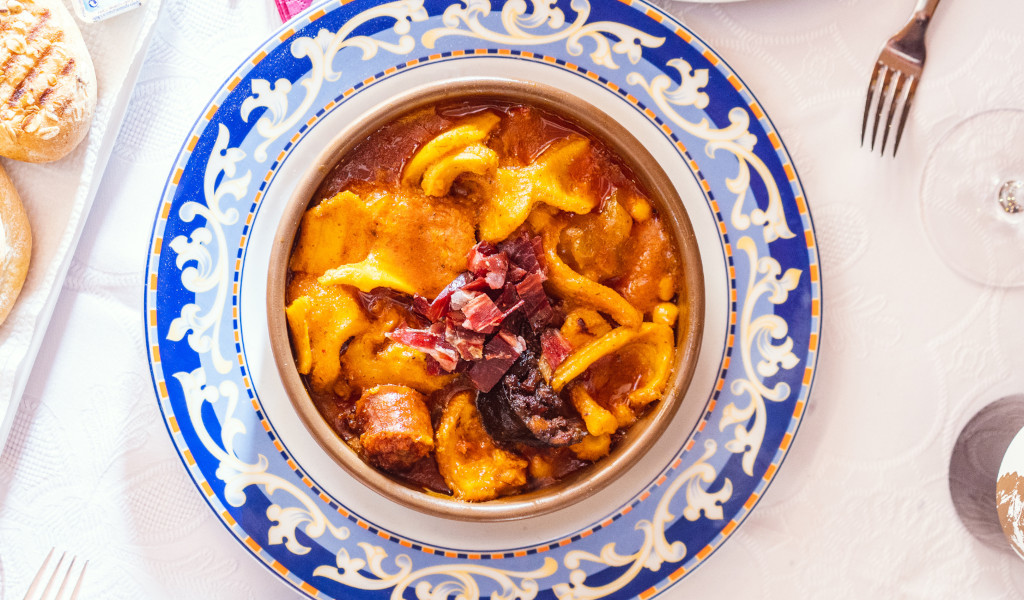 Tenerife stew with chickpeas on a decorative plate, served at the table.