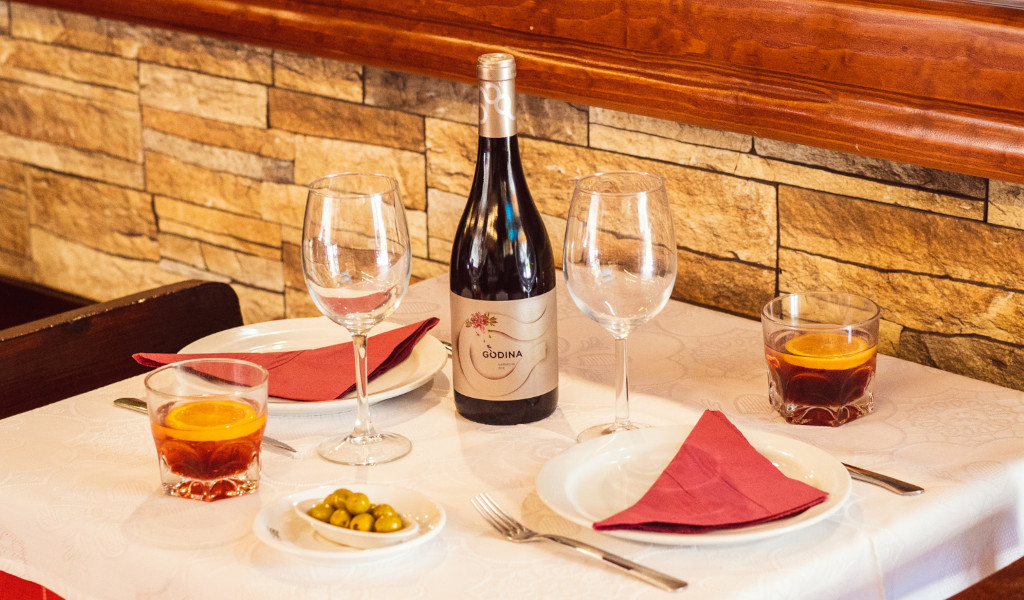 Table in a restaurant in Tenerife with glasses, bottle of Gondola wine and glasses with drinks.