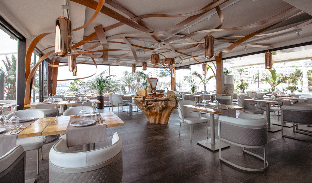 Modern restaurant with elegant décor in Tenerife, tables arranged near large windows.