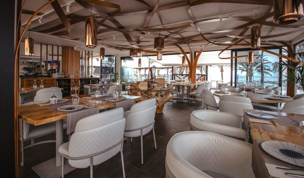 Elegant restaurant with tables prepared in Tenerife, exterior view with palm trees.