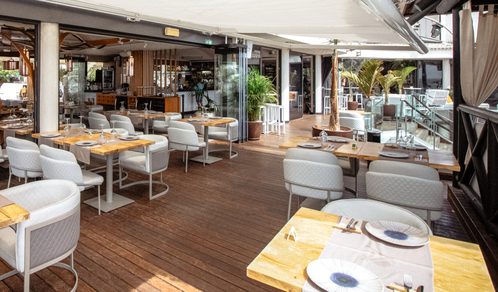 Restaurant terrace in Tenerife with tables and chairs, modern décor.