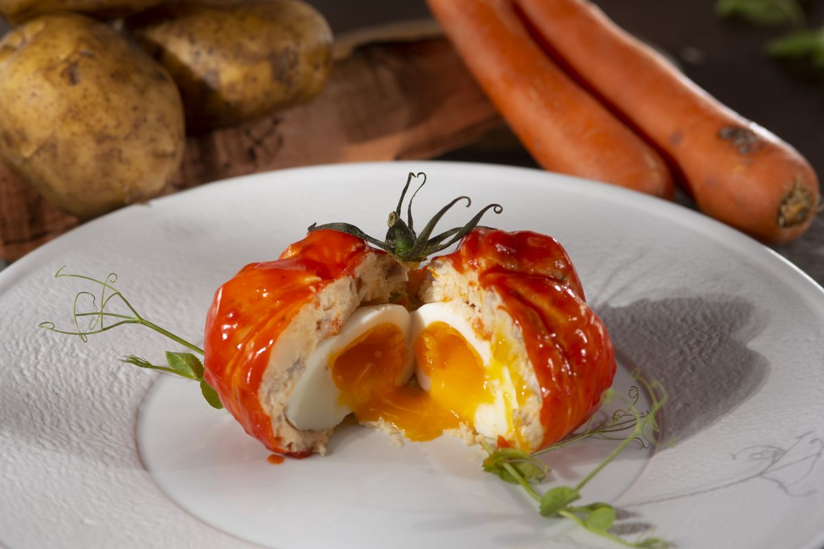 Tomato stuffed with egg on a plate, surrounded by carrots and potatoes in Tenerife.