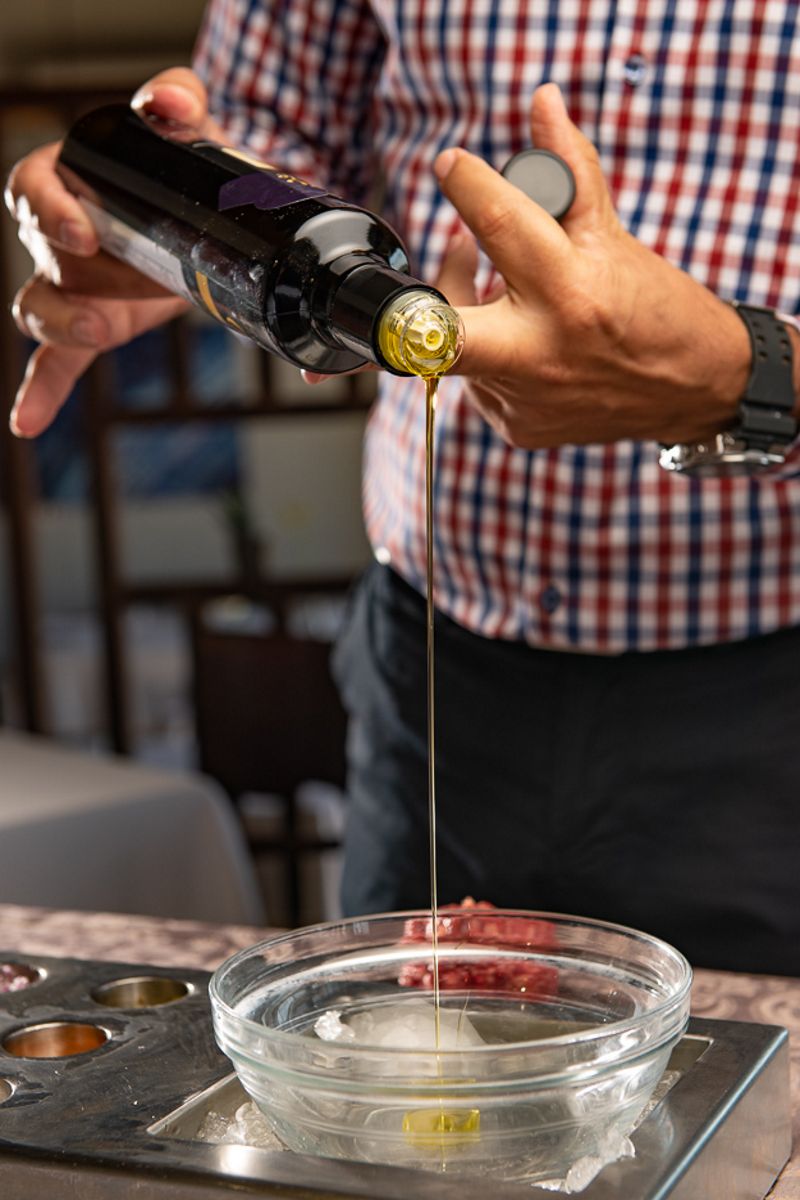 Oil pouring into a glass bowl on a table in Tenerife.