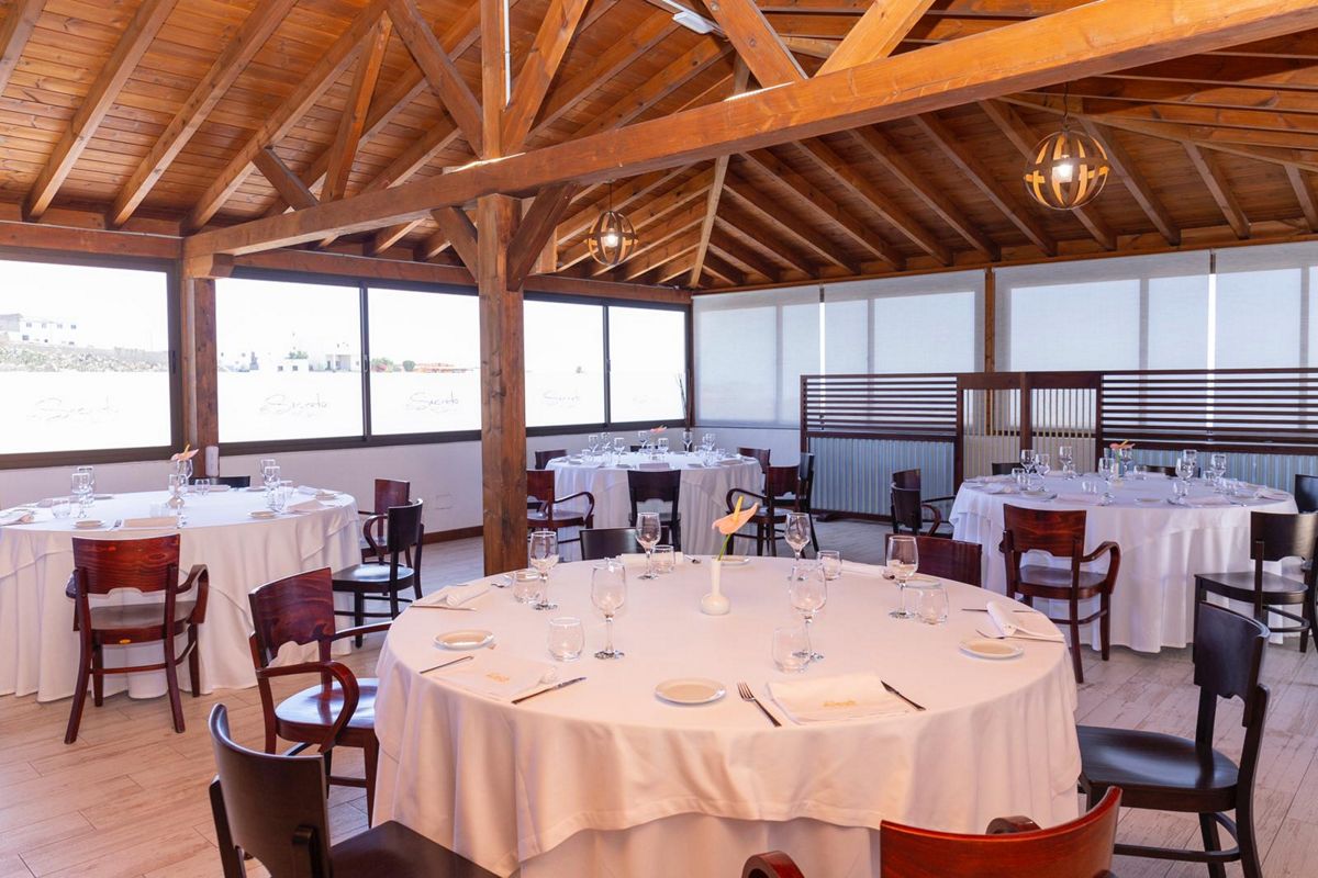 Dining room with round tables and wooden chairs in a restaurant in Tenerife.