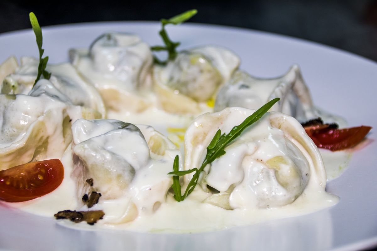 Pasta stuffed with white sauce and tomato on a plate in Tenerife.