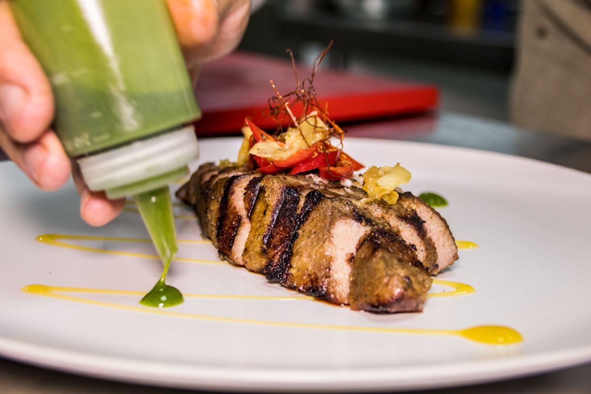 Roast meat with green sauce on a plate, served in Tenerife.