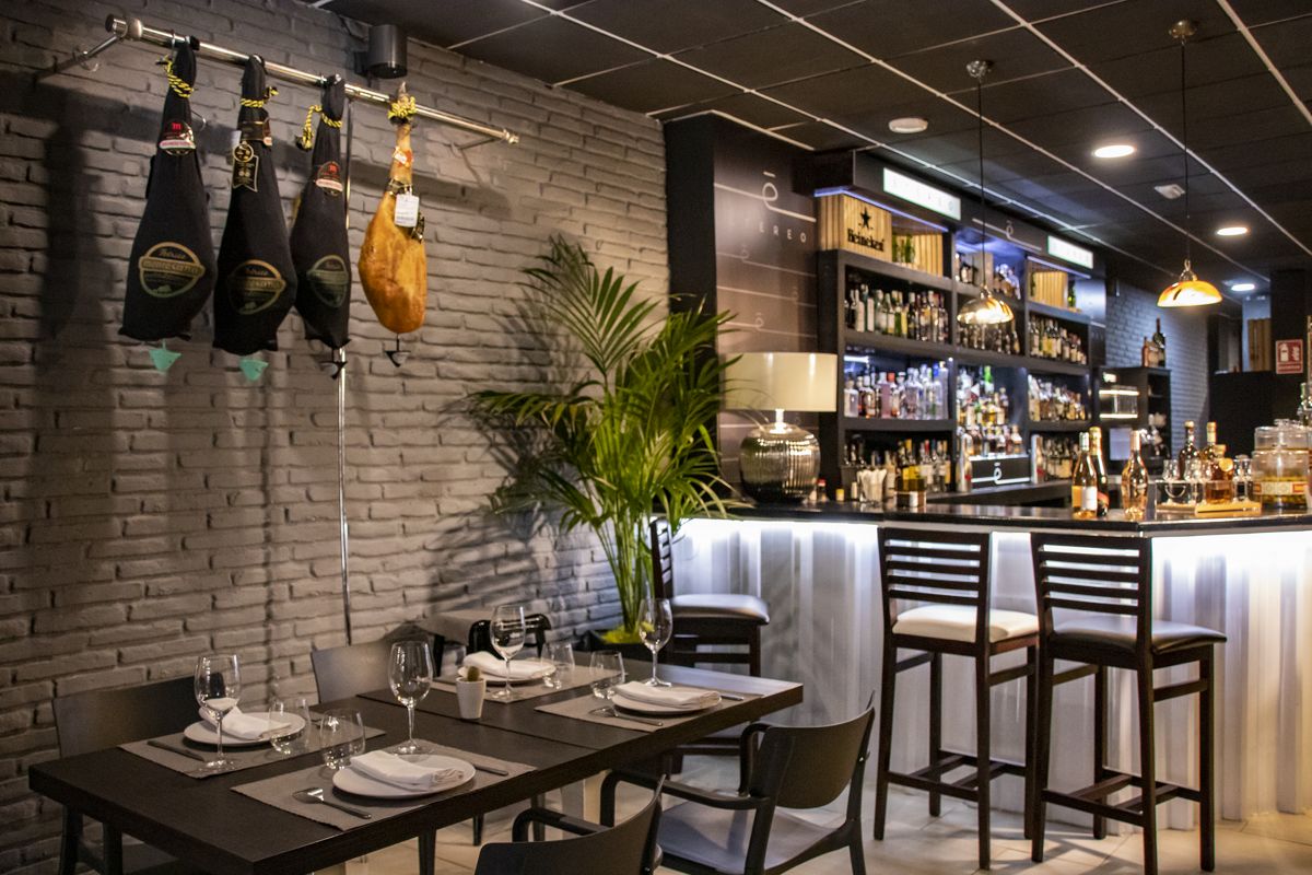 Bar with hanging hams and a table prepared in a restaurant in Tenerife.