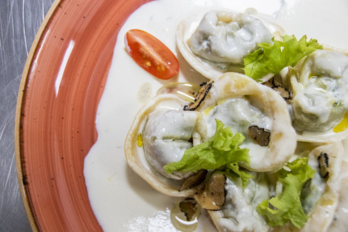 Tortellini with truffle and lettuce in white sauce, presented on a plate in Tenerife.