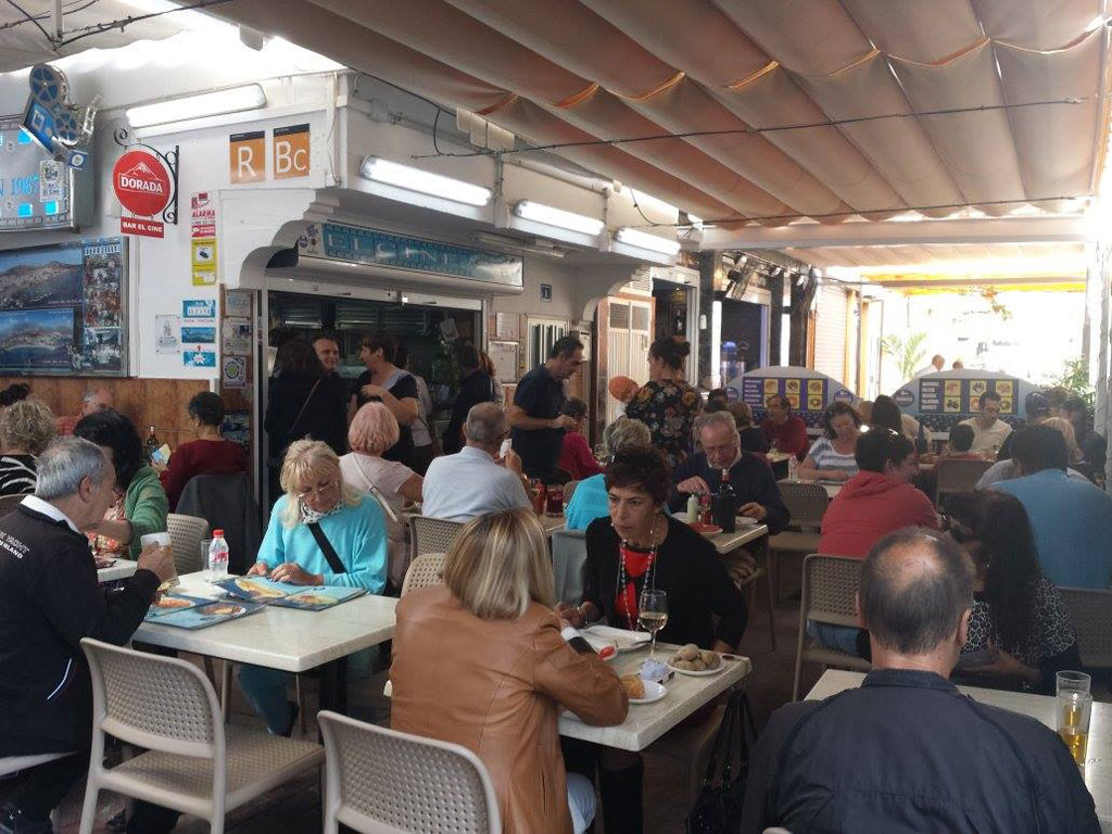People dining in a restaurant in Tenerife, with a menu and decoration visible.