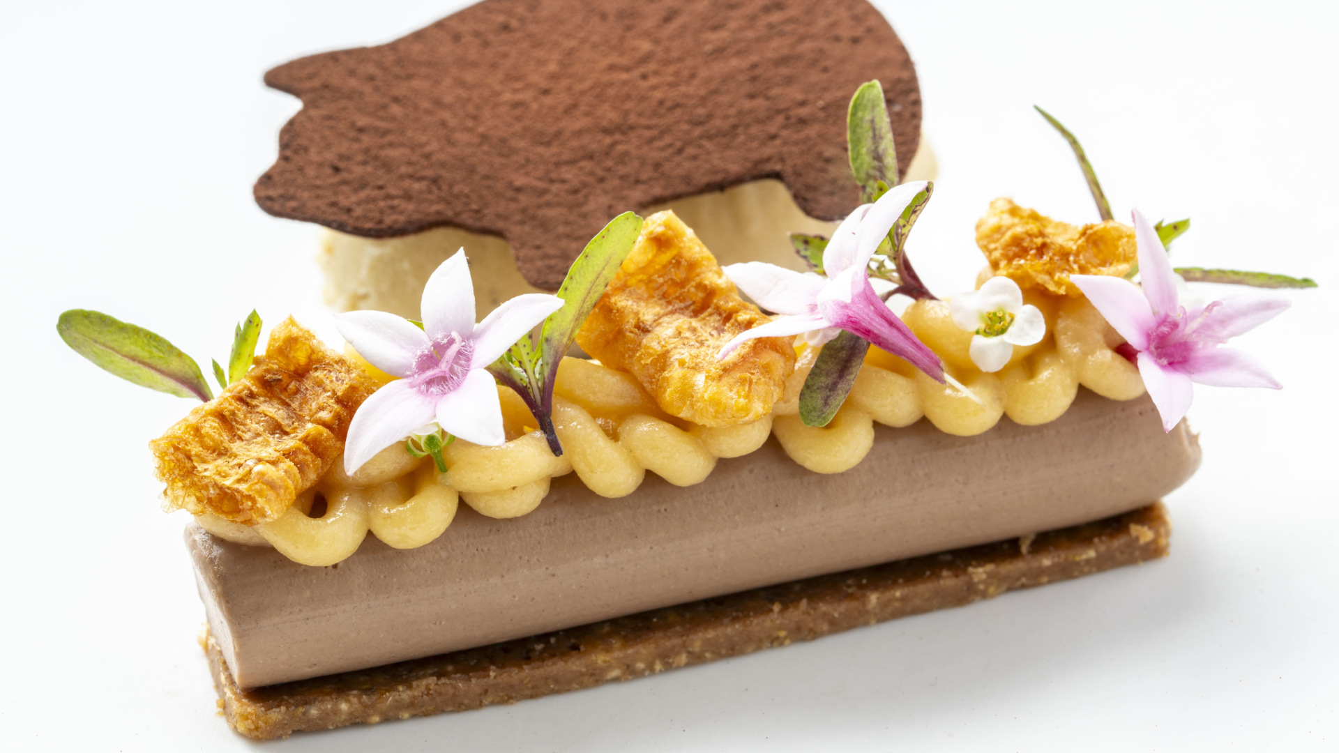 Dessert decorated with flowers and a chocolate wafer in Tenerife.