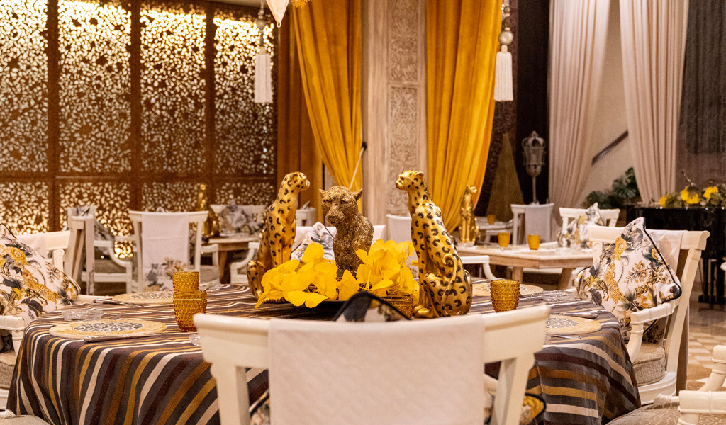 Dining room decorated with cheetah figures and yellow flowers in Santa Cruz de Tenerife.
