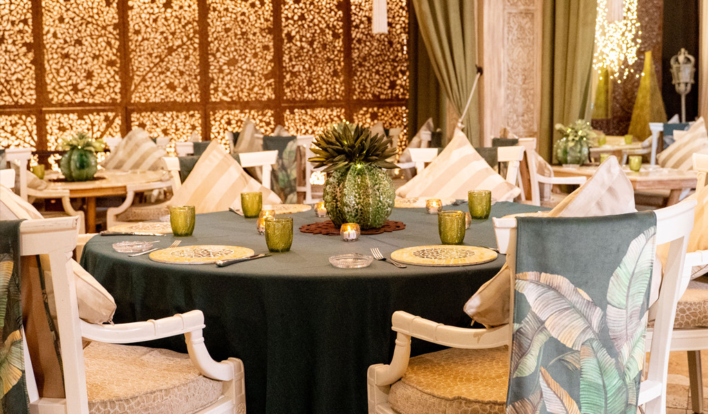 Table decorated in a restaurant in Tenerife with plates, glasses and cushions.