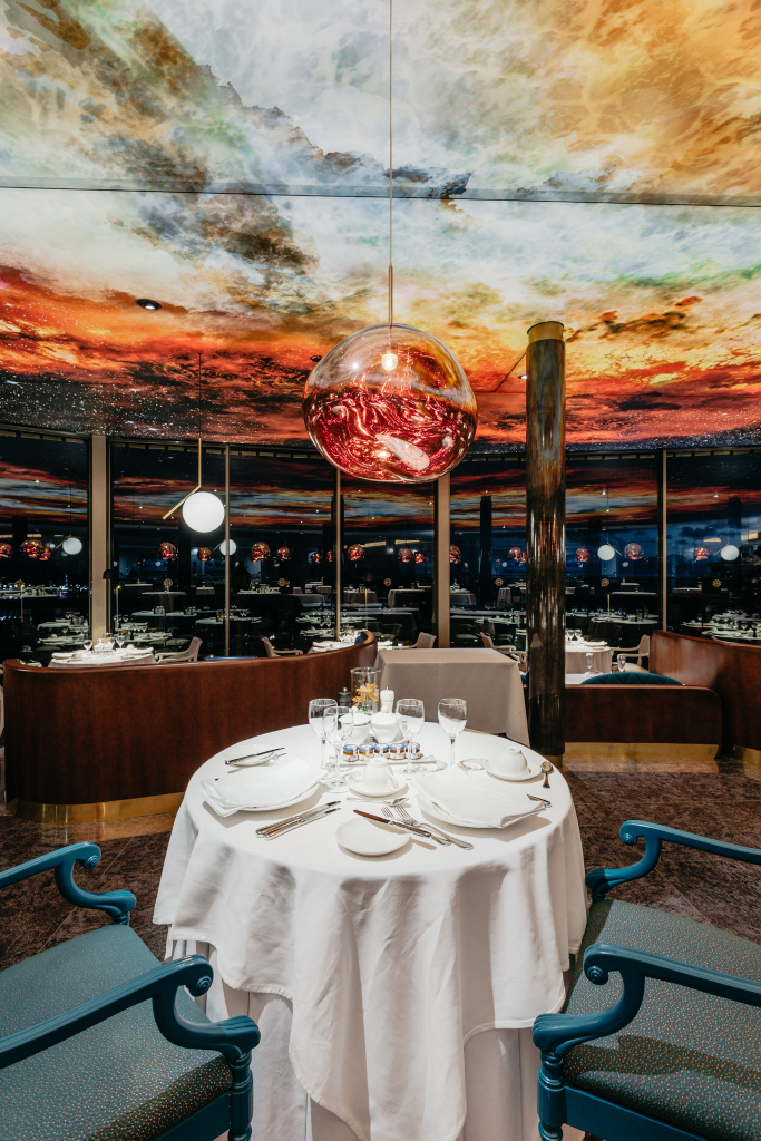 Table with glasses and dishes under a painted ceiling in a restaurant in Tenerife.