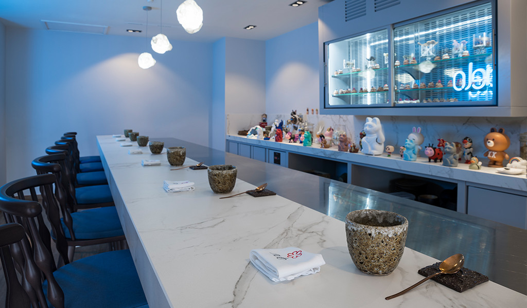 Sushi bar with figure decoration and blue chairs in a restaurant in Tenerife.