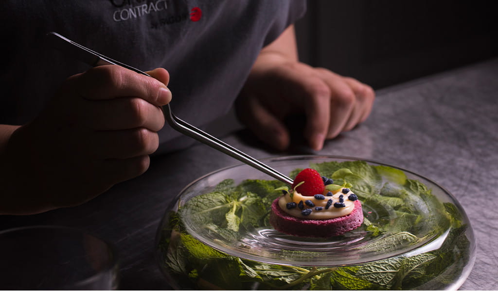 Dessert decoration with tongs on a plate with mint leaves in Tenerife.