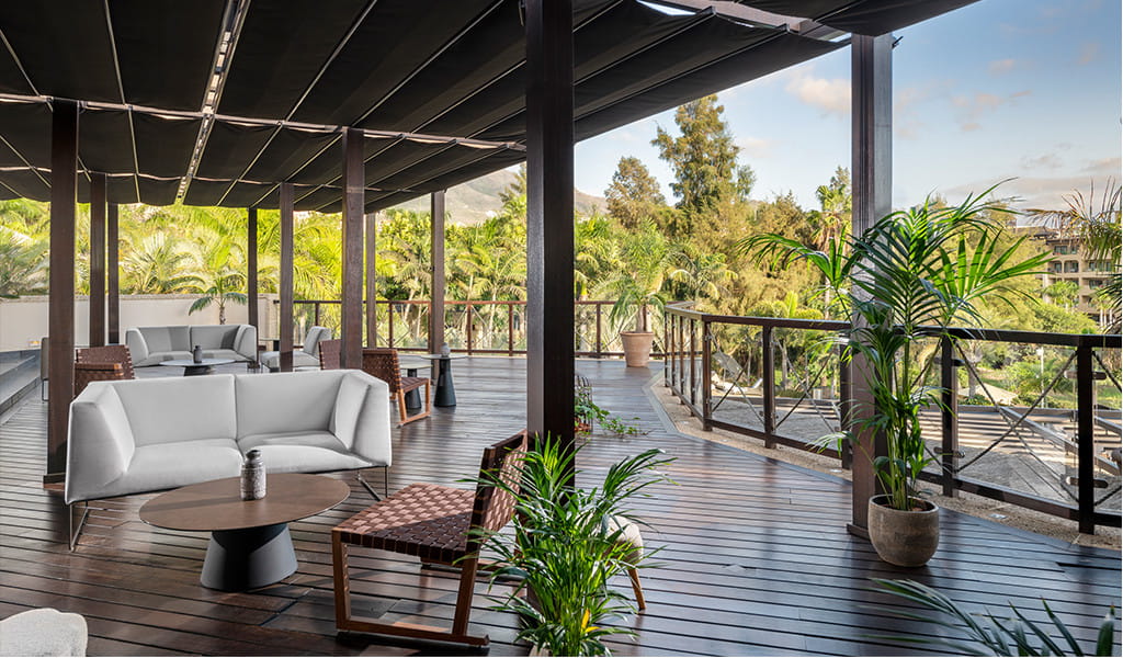 Terrace with outdoor furniture surrounded by tropical plants in Tenerife.