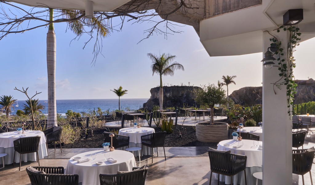Restaurant terrace with sea view and palm trees in Tenerife.