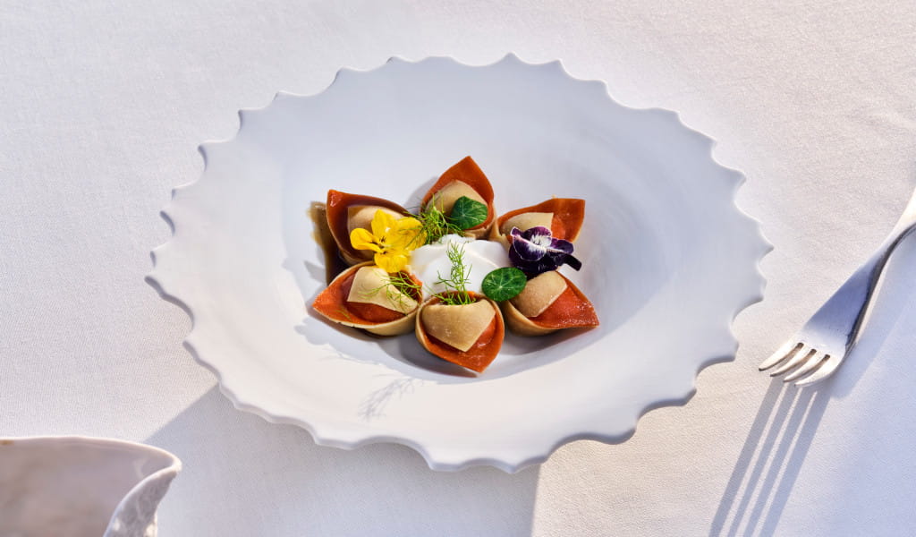 Gourmet dish decorated with flowers and herbs on a restaurant table in Tenerife.
