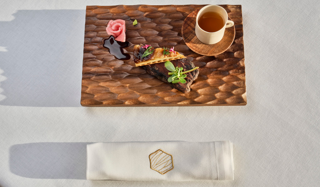 Meat dish with garnish and cup of drink on the table in Tenerife.
