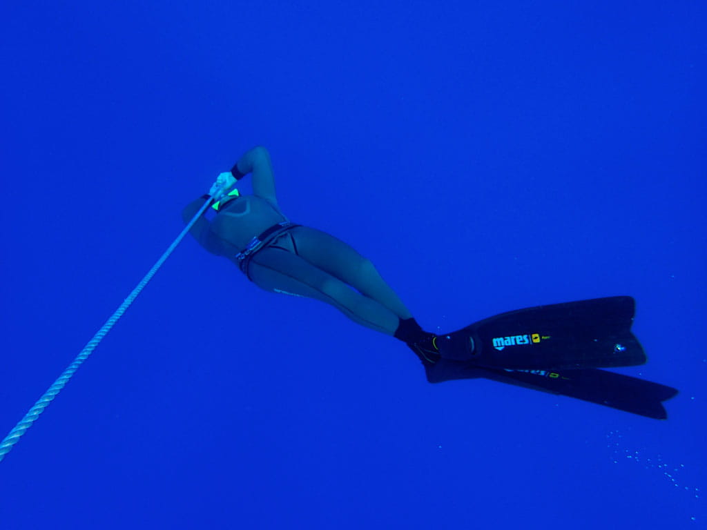 Person diving in the deep blue sea near Tenerife, using Mares brand fins.