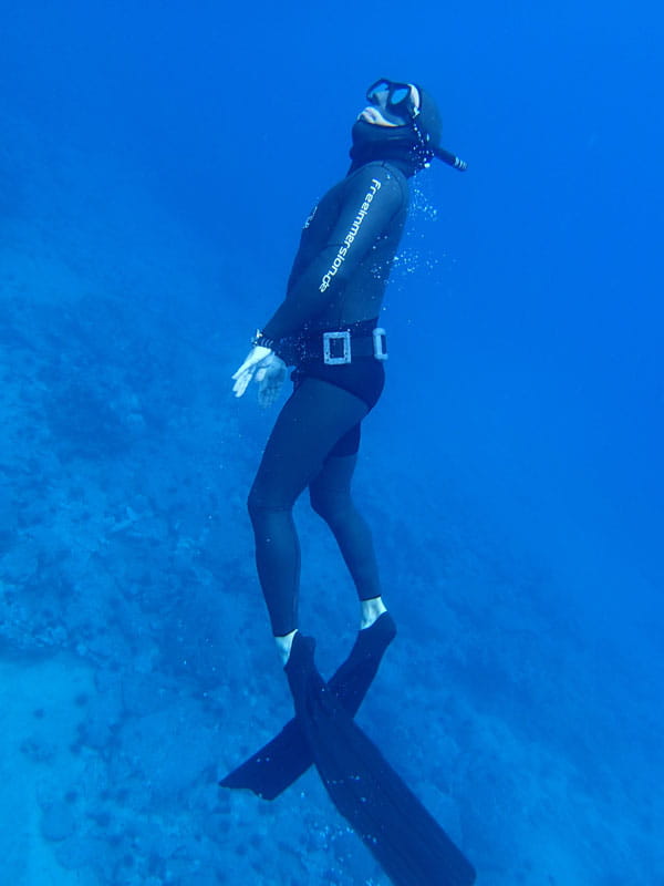 Diver in Tenerife waters with a suit and black fins.