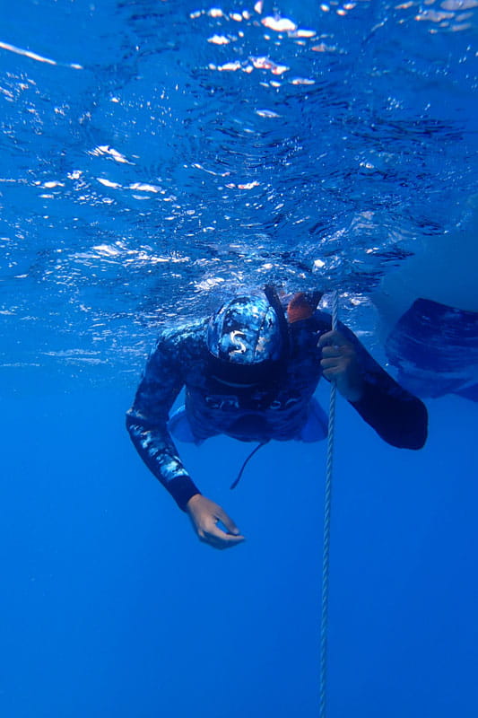 Underwater diver holding a rope in the waters of Tenerife.