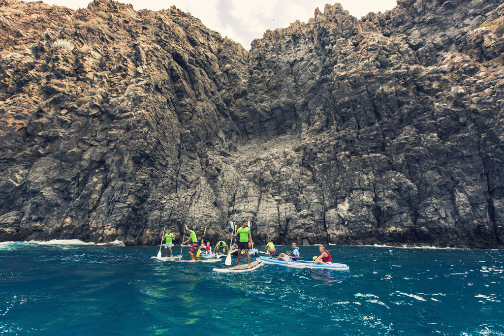 People paddle surfing in front of cliffs in Tenerife.
