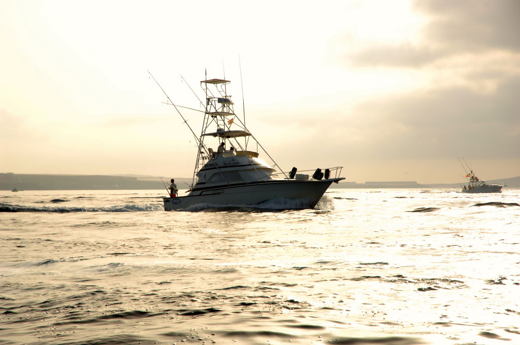 Fishing boat sailing at sunset near the coast of Tenerife.