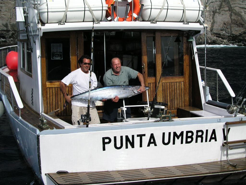 People on a fishing boat Punta Umbria hold a large fish off the coast of Tenerife.