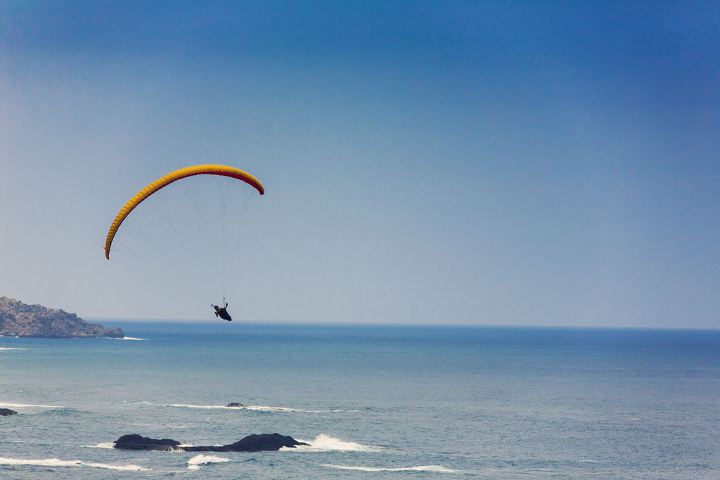Paragliding over the coast of Tenerife with the ocean in the background.