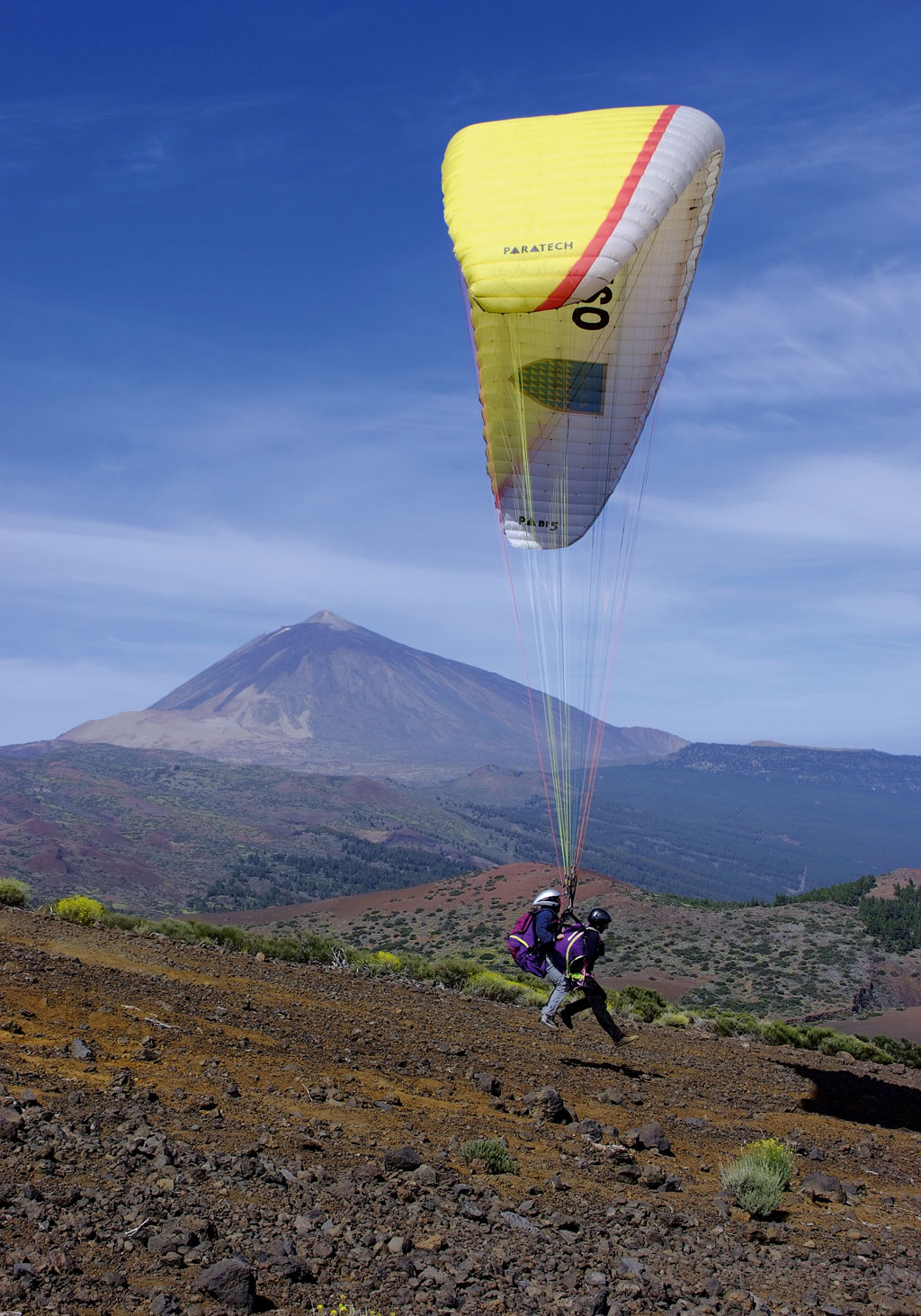 Paragliding over the landscape of Teide in Tenerife with two pilots.