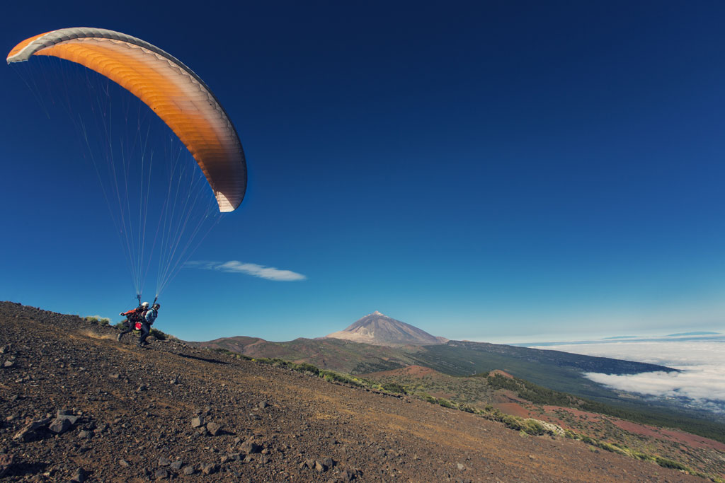 Paraglider taking off from a hillside near Mount Teide in Tenerife.