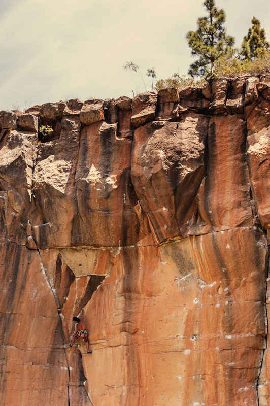 Rock wall climber in Arico, Tenerife, under a clear sky.