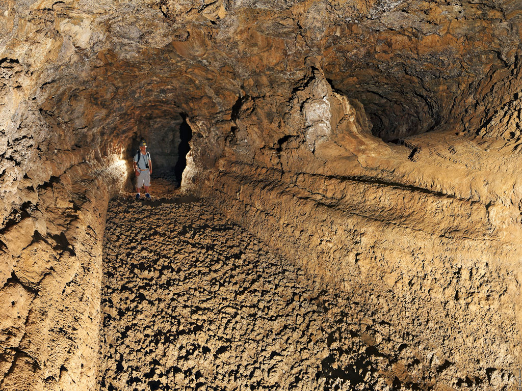 Person exploring volcanic cave in Tenerife.