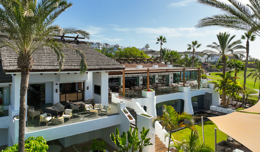 Restaurant terrace surrounded by palm trees in Tenerife.