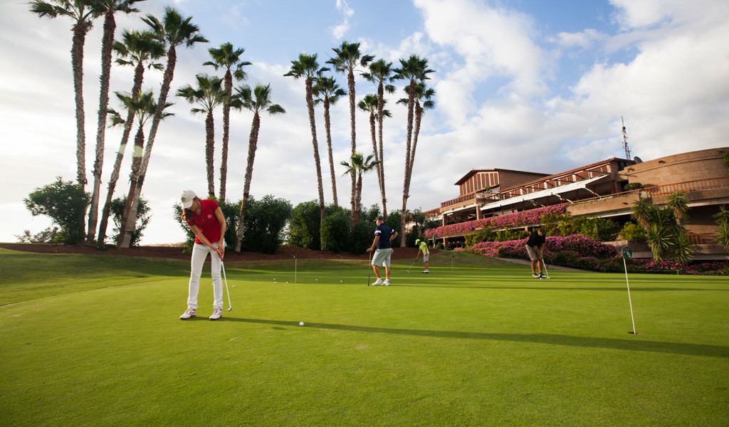 Golfers on a course surrounded by palm trees in Tenerife.