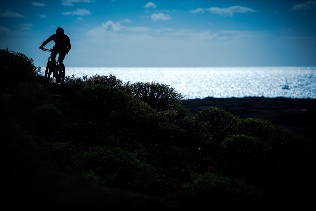 Cyclist on coastal path with sea view in Tenerife.