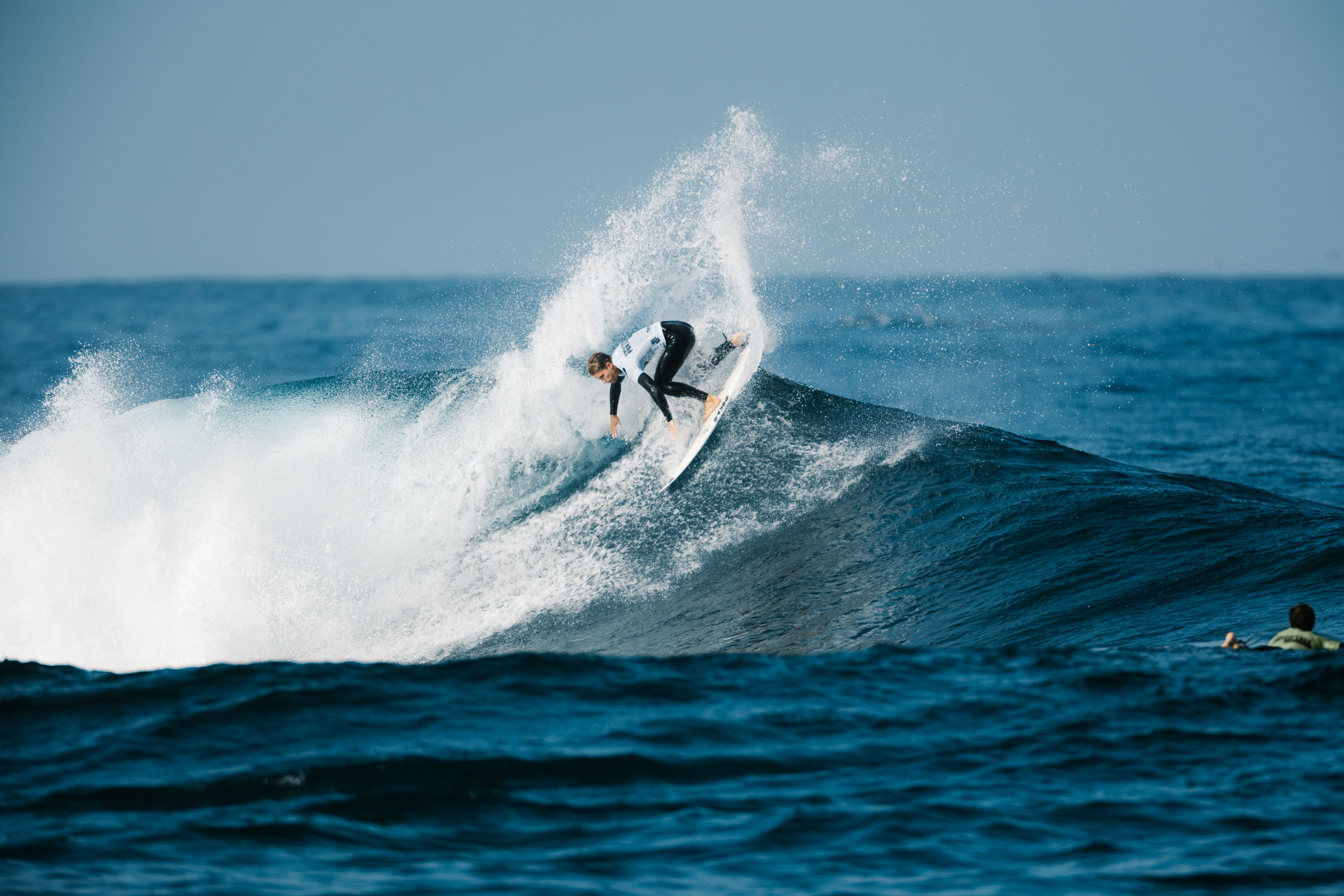 Surfer on a wave in Tenerife under clear skies.