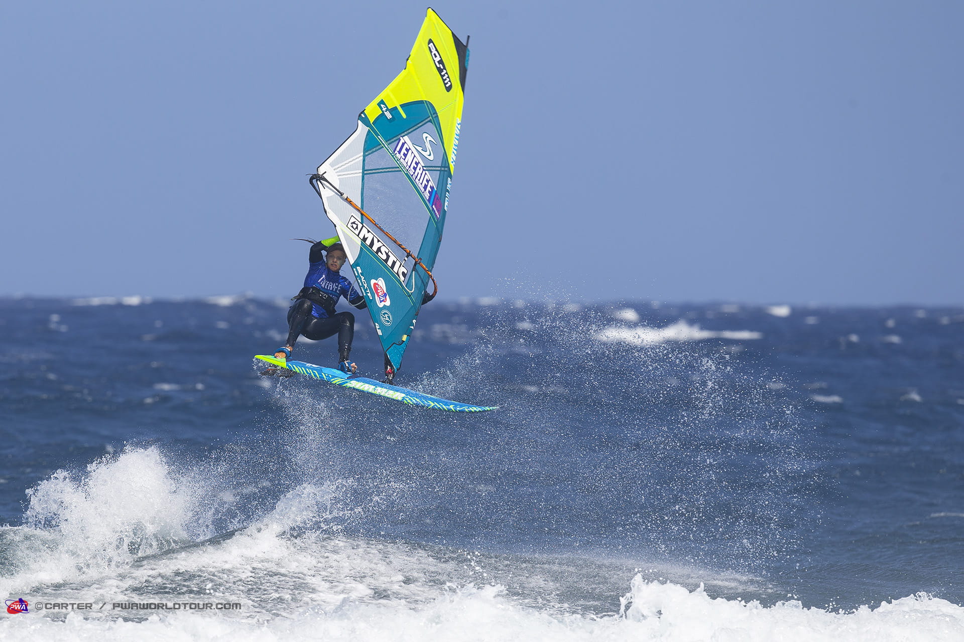 Person windsurfing in the sea with a sail that says Tenerife.