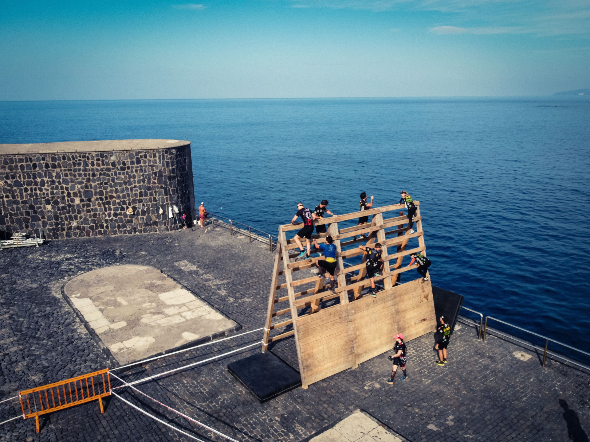 People climbing a wooden structure by the sea in Puerto de la Cruz, Tenerife.