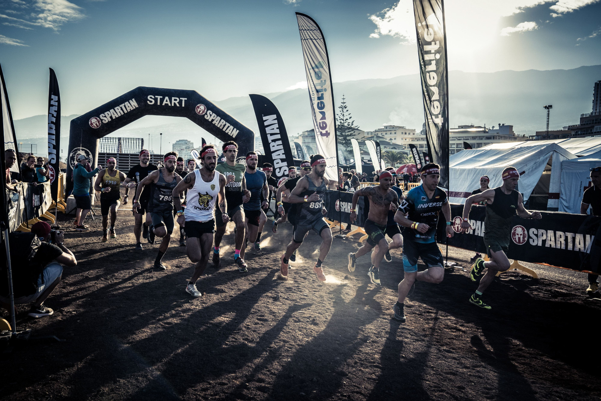 Runners starting a Spartan race in Tenerife under a starting arch.
