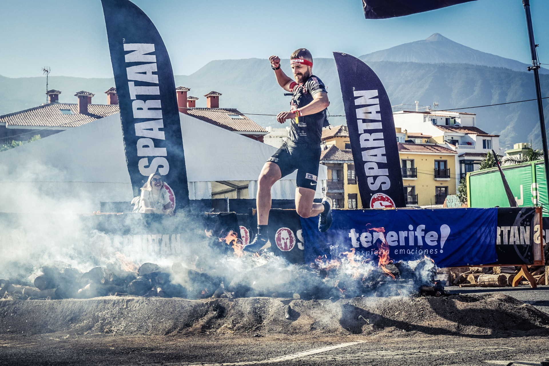 Runner jumping over fire in Spartan race in Tenerife.